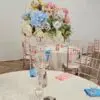 Tall glass vase with pastel floral centerpiece for baby shower table setup