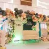 White loveseat on baby shower stage with balloon arch and teddy bear props