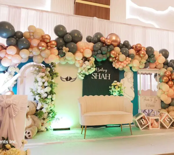 White loveseat on baby shower stage with balloon arch and teddy bear props