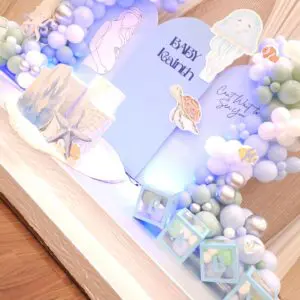 Jellyfish, turtle, and coral props on baby shower backdrop