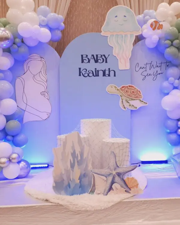 Coral and starfish props with blue baby shower arch