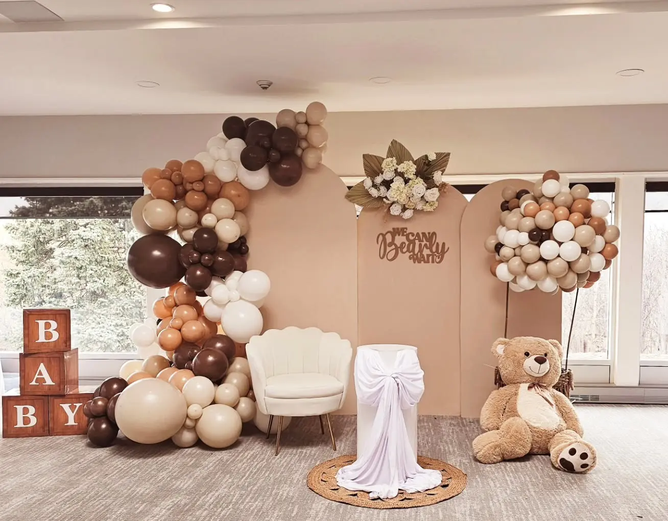 Neutral balloon garland setup for bridal shower in Brampton with brown, beige, and white balloons, “We Can Bearly Wait” sign, and teddy bear