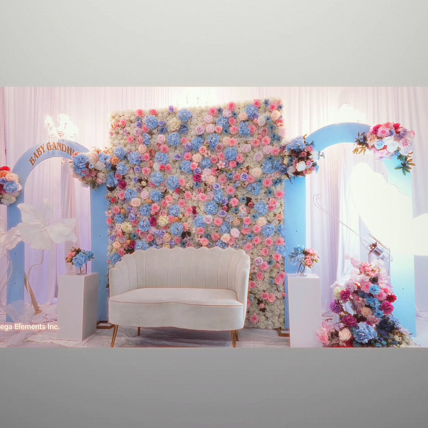 Full baby shower stage decor with arches and white flower accents