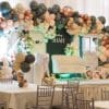 Baby shower rose gold “BABY” blocks in front of balloon garland