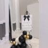 Welcome sign with black bow and white floral balloon base for birthday party