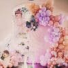 Whimsical first birthday backdrop with pastel balloons and fairy decorations at home