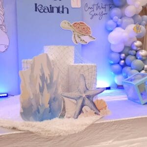Coral and starfish props with blue baby shower arch
